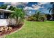 Well-maintained backyard with lush lawn, landscaping, and mature trees at 466 Sunnyside Dr, Venice, FL 34293