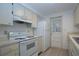 Bright kitchen featuring white appliances, ample counter space, and wood-look flooring at 466 Sunnyside Dr, Venice, FL 34293