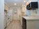 Bright kitchen featuring white appliances, ample counter space, and wood-look flooring at 466 Sunnyside Dr, Venice, FL 34293