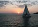 Sailboat sailing into a vibrant sunset, offering a peaceful escape and stunning waterfront views at 466 Sunnyside Dr, Venice, FL 34293