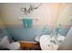Cozy bathroom with a pedestal sink, decorative accents, and a floral motif at 4754 Sabal Key Dr, Bradenton, FL 34203