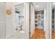 Hallway view of bathroom with shower/tub, tile floor, and adjacent hall with open shelves and storage at 5014 Marshfield Rd # 30, Sarasota, FL 34235