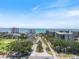 Scenic aerial view of beachfront condos with a beautiful golf course and ocean view under a bright blue sky at 524 Schooner Ln, Longboat Key, FL 34228