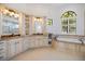 Large primary bathroom with dual vanities, a soaking tub, and elegant fixtures at 524 Schooner Ln, Longboat Key, FL 34228