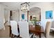 Bright dining room with wood table, white chairs, modern chandelier, and archway to kitchen at 524 Schooner Ln, Longboat Key, FL 34228