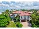 Mediterranean-style home boasting a red tile roof, lush landscaping, and a paver driveway at 524 Schooner Ln, Longboat Key, FL 34228