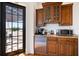 Wet bar with custom cabinetry, granite counters, stainless steel appliances, and an adjacent door to the terrace at 524 Schooner Ln, Longboat Key, FL 34228