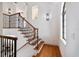 Elegant staircase with hardwood treads and black wrought iron railings, leading to the upper levels of the home at 524 Schooner Ln, Longboat Key, FL 34228