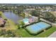 An aerial view showcasing the community pool, tennis court, and beautiful lake at 5642 29Th Street E Cir, Bradenton, FL 34203