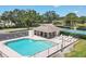 Amazing community pool area with ample seating, a shade structure, and a scenic view of the tennis courts at 5642 29Th Street E Cir, Bradenton, FL 34203