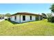 Well-maintained backyard showcasing a lush lawn, stucco exterior, and tile roof at 6007 Vivienda Dr # 29, Bradenton, FL 34207