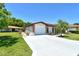 Inviting single-story home featuring a long driveway, a two-car garage, and a beautifully maintained lawn at 6007 Vivienda Dr # 29, Bradenton, FL 34207