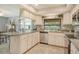 Bright kitchen features white cabinetry and breakfast bar with dining room view at 6007 Vivienda Dr # 29, Bradenton, FL 34207