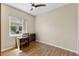Bedroom featuring wood flooring, ceiling fan, desk, and a window view of the neighborhood at 6532 Copper Ridge Trl, Bradenton, FL 34201