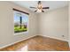 Bedroom featuring wood flooring, ceiling fan, and window view of the landscaped neighborhood at 6532 Copper Ridge Trl, Bradenton, FL 34201