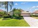 Well-kept home boasts a paved driveway, two-car garage, lush lawn, and mature landscaping at 6532 Copper Ridge Trl, Bradenton, FL 34201
