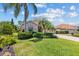Charming single Gathering home with lush green lawn, mature trees, and colorful landscaping at 6532 Copper Ridge Trl, Bradenton, FL 34201