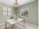 Home office features a large window, stylish light fixture, and neutral decor at 6532 Copper Ridge Trl, Bradenton, FL 34201