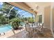 Covered patio featuring outdoor seating and dining, plus views of the pool and green backyard at 6532 Copper Ridge Trl, Bradenton, FL 34201
