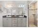 A luxurious bathroom features a double sink vanity with a shower behind glass doors at 6708 162Nd E Pl, Parrish, FL 34219