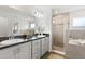 Bright primary bathroom boasts double vanity sinks, glass enclosed shower, and separate soaking tub at 6708 162Nd E Pl, Parrish, FL 34219