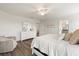Comfortable bedroom boasts a ceiling fan, wood floors, and a bright ambiance from the adjacent bathroom at 6708 162Nd E Pl, Parrish, FL 34219