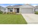 Charming single-story home with a well-manicured lawn, two-car garage, and inviting front porch at 6708 162Nd E Pl, Parrish, FL 34219