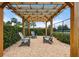 Relaxing outdoor lounge area with pergola and Adirondack chairs surrounded by lush greenery near the courts at 6708 162Nd E Pl, Parrish, FL 34219