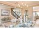 Elegant dining room with stylish chandelier, staircase, and tasteful decor creates a warm and inviting ambiance at 6916 Prairie Oak Way, Nokomis, FL 34275