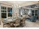Elegant dining room bathed in natural light, showcasing stylish chandelier and sophisticated decor at 6916 Prairie Oak Way, Nokomis, FL 34275