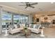 Bright living room with a ceiling fan, large windows overlooking the pool, comfortable seating, and open access to the kitchen at 6916 Prairie Oak Way, Nokomis, FL 34275