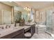 Elegant main bathroom with marble finishes, dual sinks, a soaking tub, and a glass shower at 6916 Prairie Oak Way, Nokomis, FL 34275