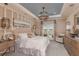 Luxurious main bedroom featuring a tray ceiling, chandelier, and access to the backyard at 6916 Prairie Oak Way, Nokomis, FL 34275