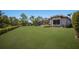 Expansive backyard featuring lush green lawn, mature trees, and meticulously manicured hedges at 7011 Belmont Ct, Lakewood Ranch, FL 34202