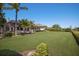 Large backyard with lush grass, screened-in lanai, and mature trees providing privacy and shade at 7011 Belmont Ct, Lakewood Ranch, FL 34202