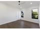 A light-filled bedroom with wood floors, white walls, and two windows at 7011 Belmont Ct, Lakewood Ranch, FL 34202