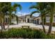 Grand home with extensive driveway, lush landscaping, and mature palm trees enhancing curb appeal at 7011 Belmont Ct, Lakewood Ranch, FL 34202