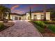 Landscaped driveway leading to a luxury Mediterranean home with tile roof at 7011 Belmont Ct, Lakewood Ranch, FL 34202