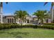 Elegant home exterior with mature palm trees and manicured landscaping enhancing the curb appeal at 7011 Belmont Ct, Lakewood Ranch, FL 34202