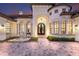 Stunning front exterior with a fountain, arched entryway, and manicured landscaping at 7011 Belmont Ct, Lakewood Ranch, FL 34202