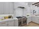 The chef's kitchen has a stainless steel stove, white cabinetry, and stone countertops at 7011 Belmont Ct, Lakewood Ranch, FL 34202