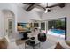 Spacious living room with a large screen TV, modern decor, and access to a screened pool area at 7011 Belmont Ct, Lakewood Ranch, FL 34202