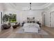 Tranquil main bedroom featuring tray ceilings, hardwood floors, and a sitting area with large windows at 7011 Belmont Ct, Lakewood Ranch, FL 34202