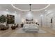 Spacious main bedroom with tray ceiling, decorative lighting, sitting area, and large windows offering serene outdoor views at 7011 Belmont Ct, Lakewood Ranch, FL 34202