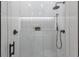 Modern shower area with white tile, a rainfall showerhead, and sleek black fixtures at 7011 Belmont Ct, Lakewood Ranch, FL 34202