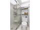 Bright bathroom showcasing a shower with glass doors, toilet and storage at 7218 Cloister Dr # 7218, Sarasota, FL 34231