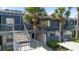 Blue two-story condo with balcony access, featuring well-maintained landscaping and a shared stairway at 7218 Cloister Dr # 7218, Sarasota, FL 34231