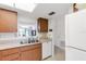 Kitchen featuring stainless steel sink and white appliances plus an adjacent pass-through window to the dining area at 7218 Cloister Dr # 7218, Sarasota, FL 34231