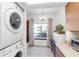 Bright laundry room with in-unit washer and dryer near an eating nook with chandelier at 7218 Cloister Dr # 7218, Sarasota, FL 34231