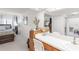 Spacious main bedroom featuring ensuite bathroom with vanity and large mirror, plus natural lighting at 7218 Cloister Dr # 7218, Sarasota, FL 34231